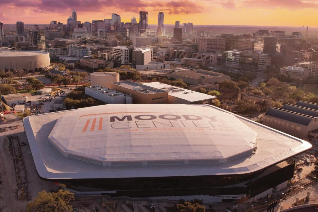 A drone shot of Moody Center with the Austin skyline in the background.
